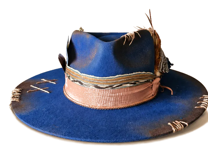 The Midnight Burnish — hand-dyed cobalt felt crown with copper burnish, blush band, and feather